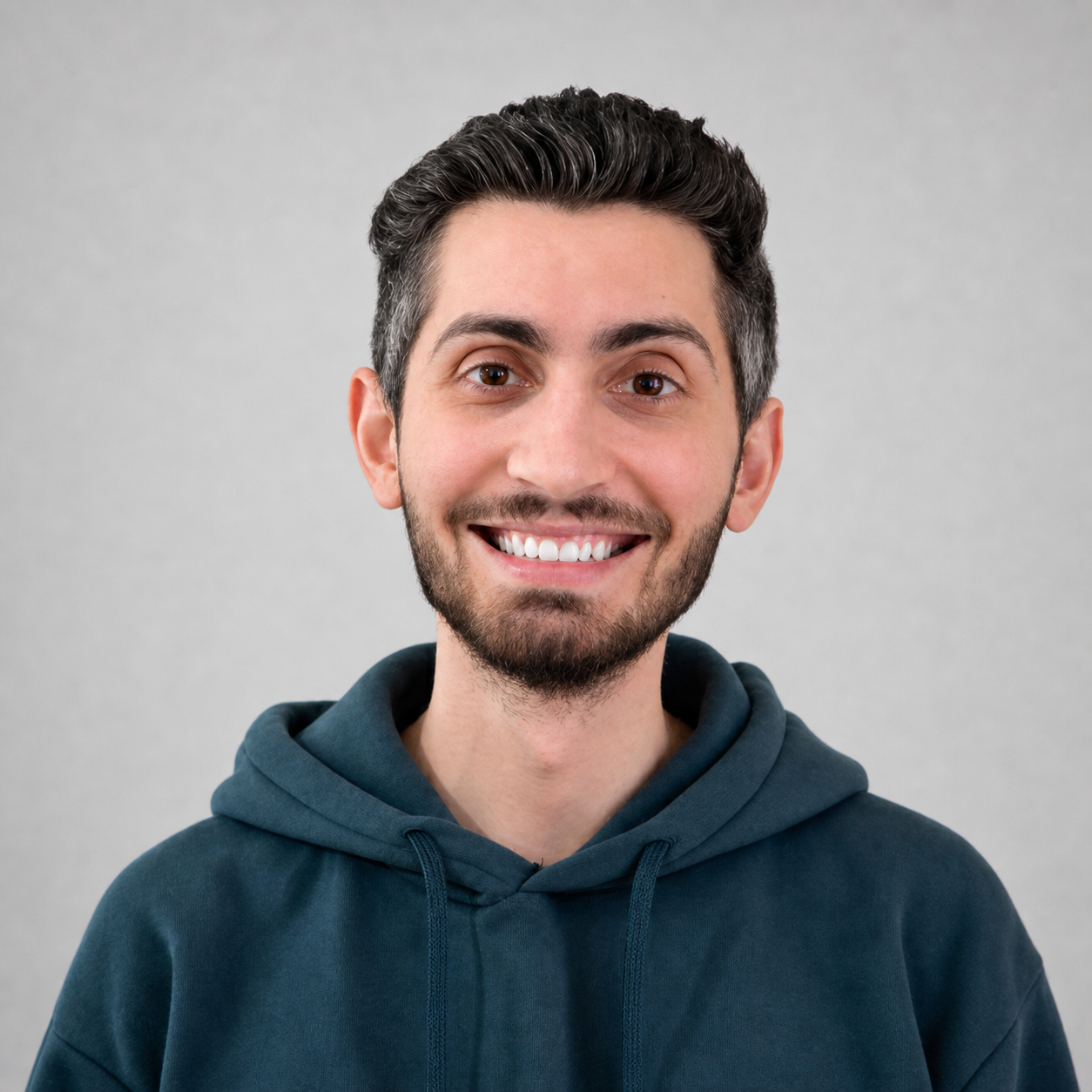 Ahmad Nouh, smiling in a deep-teal hoodie
